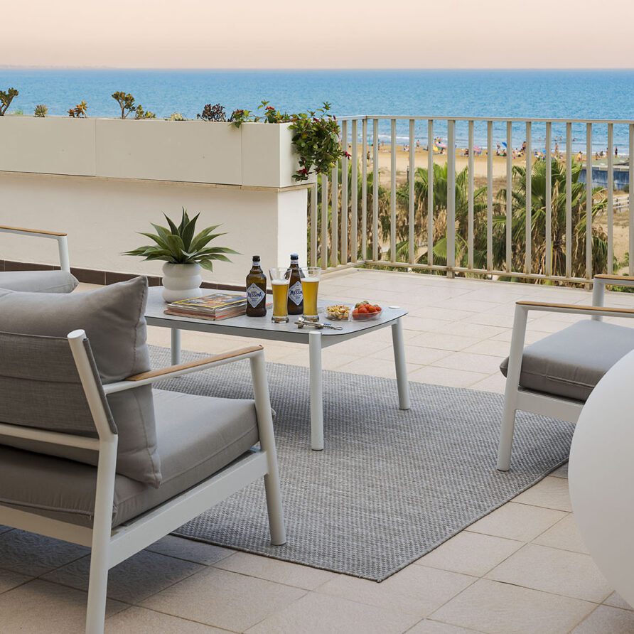 Terrazza panoramica con mobili da esterno, vista mare e area relax con sedie e tavolo