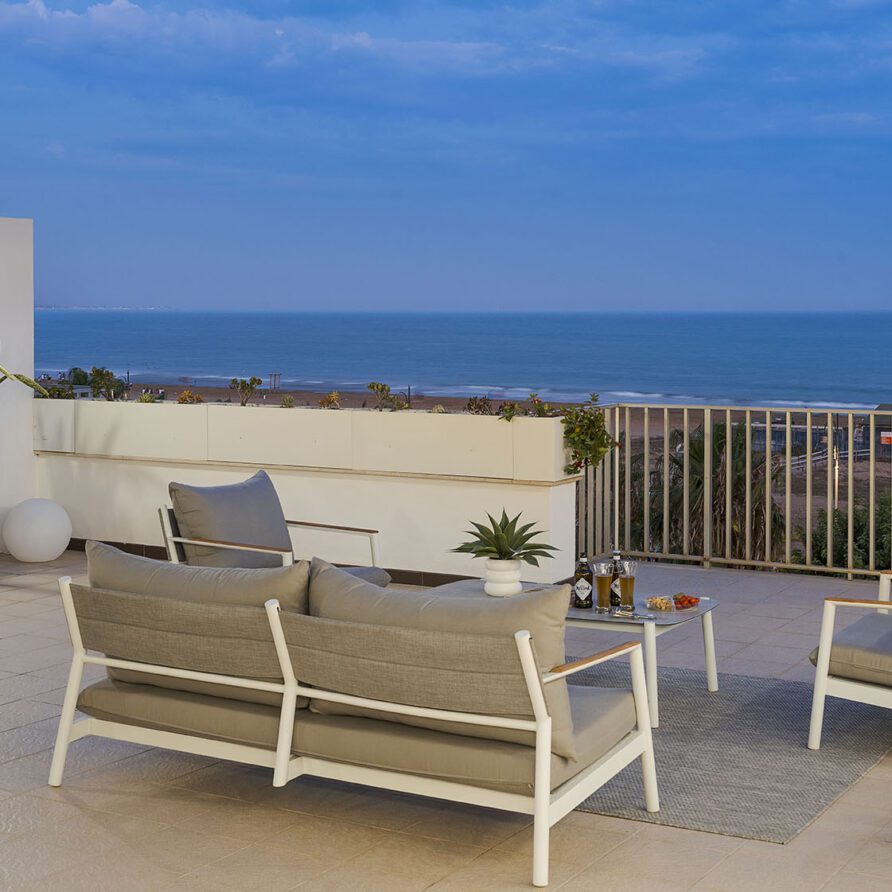 Terrazza moderna con vista mare, mobili da esterno in stile minimalista, piante decorative e cielo sereno
