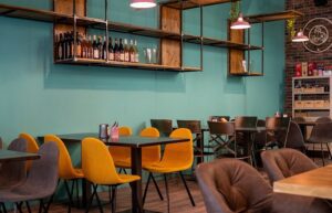 Interno di caffetteria moderna con sedie colorate e parete azzurra