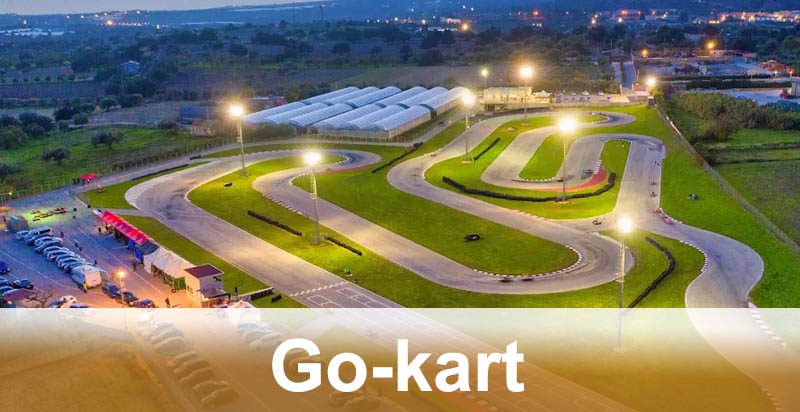 Tracciato di go-kart con curve strette e ampie aree di sorpasso in un circuito esterno illuminato di notte