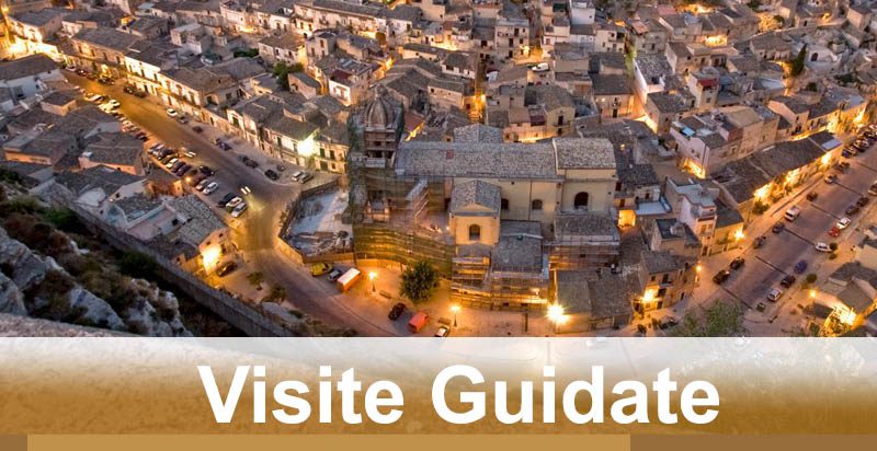 Veduta aerea della città illuminata di notte con vie affollate e edifici storici