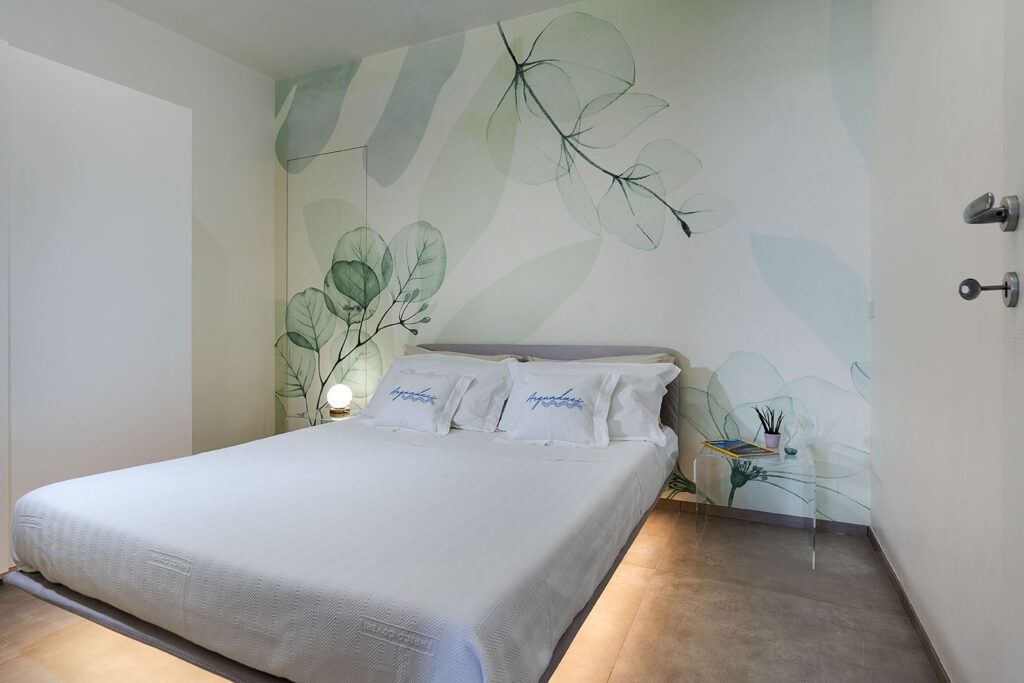 Appartamento vacanza Pozzallo. Acquaduci appartamento vacanze in Sicilia con Camera da letto moderna con pareti decorate con motivi botanici e illuminazione soffusa