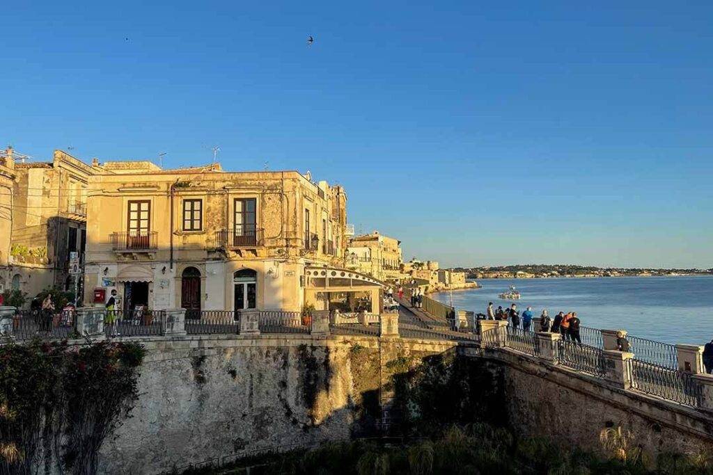 Veduta panoramica delle costruzioni storiche lungo il mare con cielo sereno e acqua calma