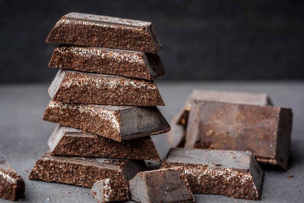 Barrette di cioccolato fondente disposte in pila su una superficie scura