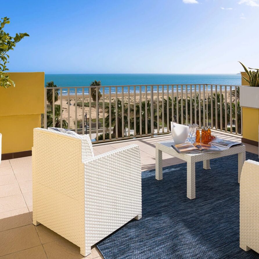 Balcone con vista mare, arredi da esterno in stile moderno, piante in vasi, atmosfera rilassante e luminosa