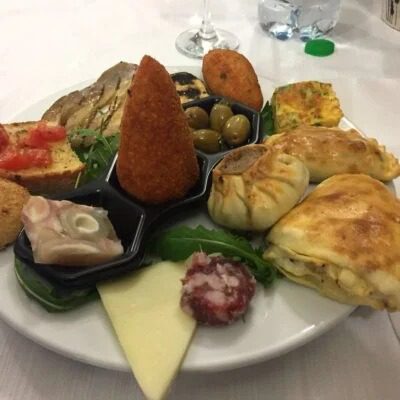 Assaggia un piatto di antipasti con crocchette, formaggi, salumi e verdure in una cena elegante