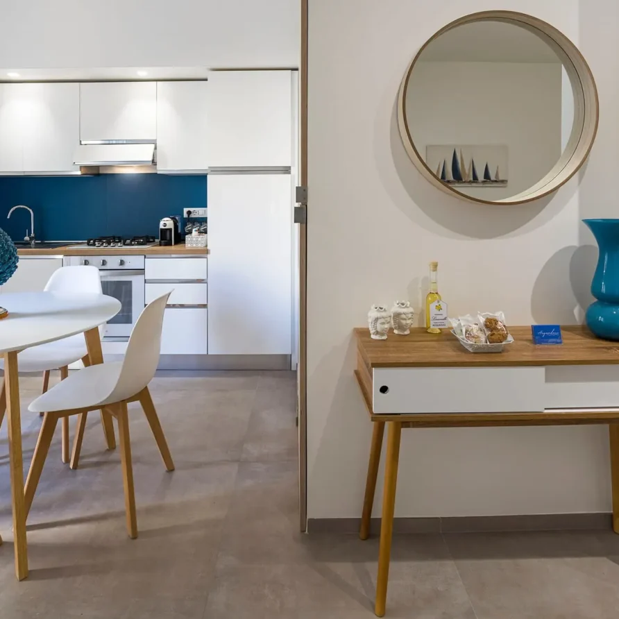 Interno di una casa moderna con soggiorno e cucina in stile minimalista con arredi bianchi e blu